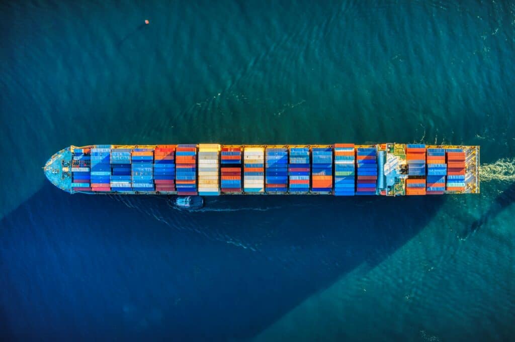 Cargo container ship transporting goods across ocean representing global trade and tariffs impact