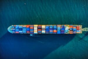 Cargo container ship transporting goods across ocean representing global trade and tariffs impact
