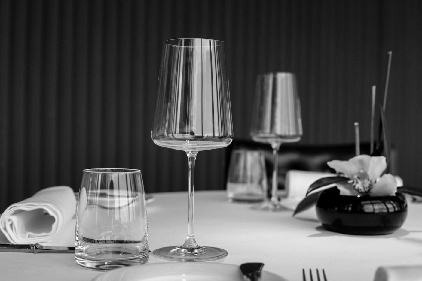 Elegant Michelin-style fine dining table setting with wine glasses and luxury restaurant presentation