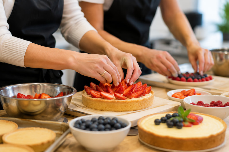 Participants preparing fresh fruit tarts during a private team building cooking class in Vancouver